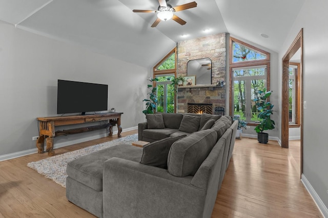 10920 Preservation Way, Richmond, IL 60071 - living area with a ceiling fan, a stone fireplace, vaulted ceiling, light wood-style flooring, and baseboards