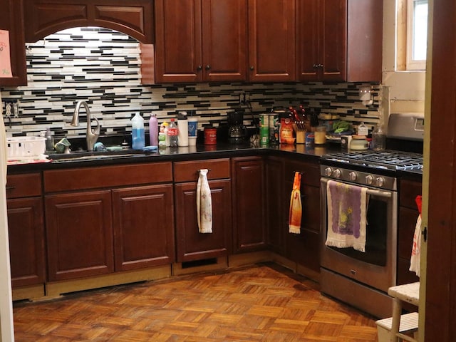 312 S Monroe St, Streator, IL 61364 - kitchen featuring stainless steel range with gas stovetop, a sink, backsplash, and dark countertops