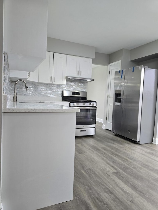 177 E Fullerton Ave, Glendale Heights, IL 60139 - kitchen featuring appliances with stainless steel finishes, under cabinet range hood, a sink, wood finished floors, and white cabinetry