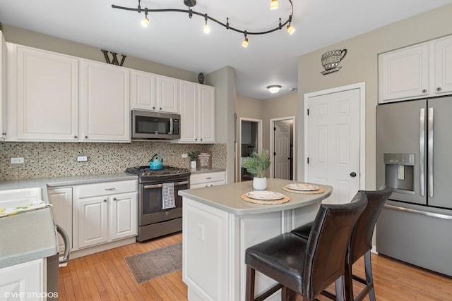 31730 N Clearwater Dr, Lakemoor, IL 60051 - kitchen featuring stainless steel appliances, light wood-style flooring, white cabinetry, and backsplash
