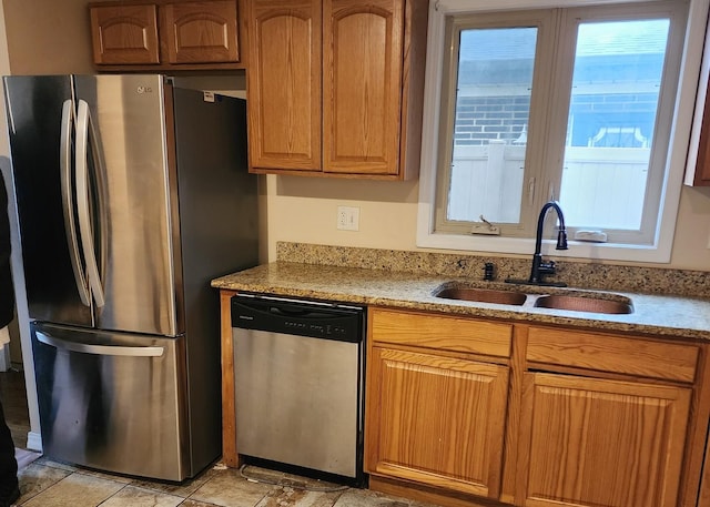 526 Marquette Ave, Calumet City, IL 60409 - kitchen featuring appliances with stainless steel finishes, a sink, brown cabinetry, and light stone counters