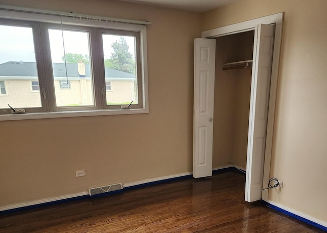 526 Marquette Ave, Calumet City, IL 60409 - unfurnished bedroom with dark wood finished floors, baseboards, and a closet