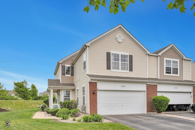 15255 Kenmare Cir, Manhattan, IL 60442 - view of front of property featuring an attached garage, a front yard, asphalt driveway, and brick siding