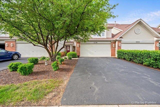 3208 Raphael Ct, Saint Charles, IL 60175 - view of property hidden behind natural elements with brick siding, asphalt driveway, and a garage