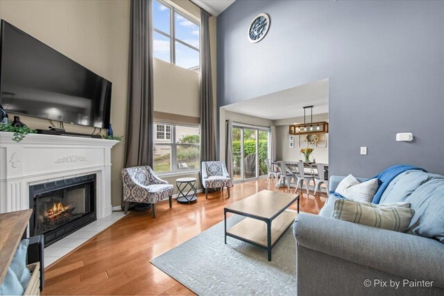 3208 Raphael Ct, Saint Charles, IL 60175 - living room with a high ceiling, a fireplace with flush hearth, wood finished floors, and a chandelier
