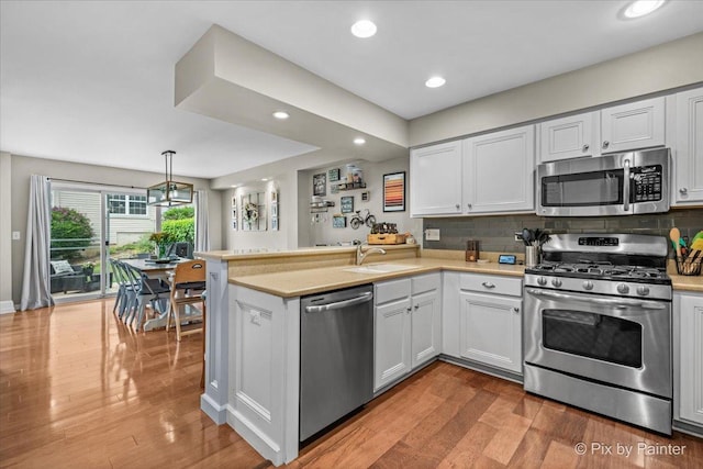 3208 Raphael Ct, Saint Charles, IL 60175 - kitchen with appliances with stainless steel finishes, a sink, a peninsula, light countertops, and recessed lighting