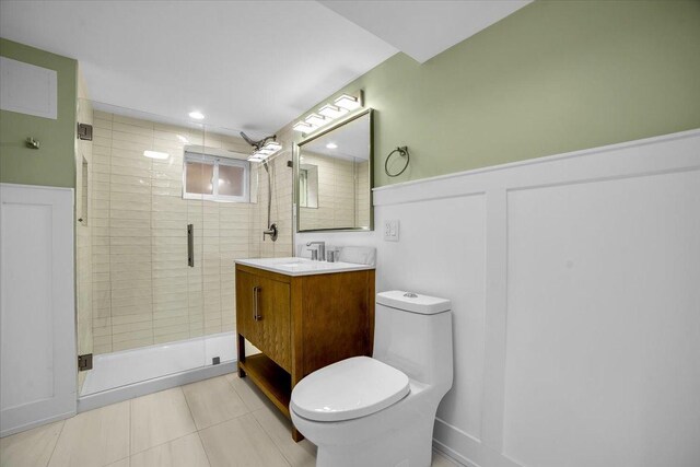 6014 W Fletcher St, Chicago, IL 60634 - full bathroom with a shower stall, vanity, toilet, wainscoting, and tile patterned floors