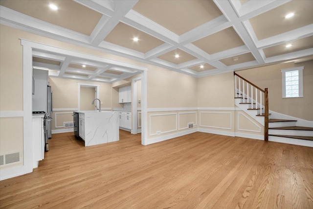 6014 W Fletcher St, Chicago, IL 60634 - unfurnished living room featuring coffered ceiling, stairs, beam ceiling, light wood-type flooring, and a decorative wall