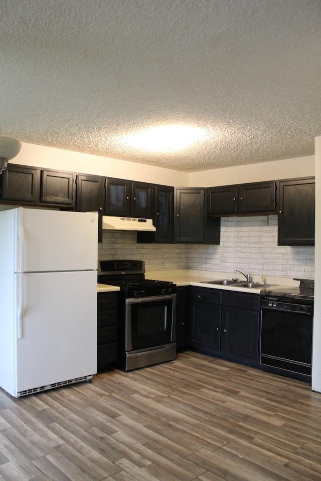 2364 S St Unit C, Elgin, IL 60123 - kitchen with stainless steel range with gas stovetop, freestanding refrigerator, dishwasher, under cabinet range hood, and wood finished floors
