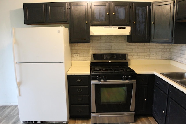 2364 S St Unit C, Elgin, IL 60123 - kitchen with freestanding refrigerator, under cabinet range hood, stainless steel range with gas cooktop, backsplash, and light countertops