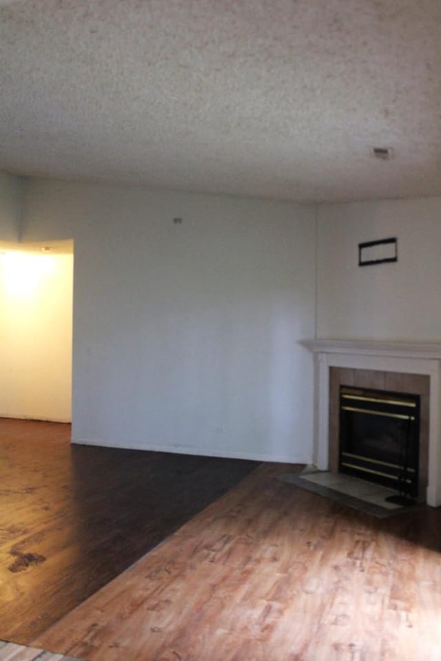 2364 S St Unit C, Elgin, IL 60123 - unfurnished living room with a tile fireplace, wood finished floors, and a textured ceiling