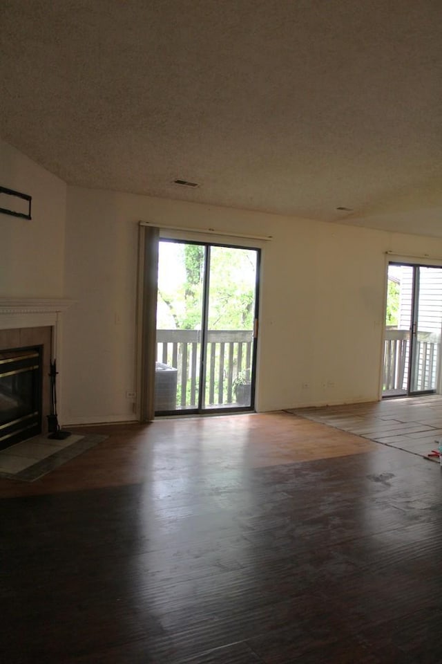 2364 S St Unit C, Elgin, IL 60123 - unfurnished living room featuring a fireplace with flush hearth, a textured ceiling, wood finished floors, and baseboards