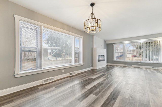 11423 S Calumet Ave, Chicago, IL 60628 - unfurnished living room featuring a chandelier, wood finished floors, baseboards, and a glass covered fireplace