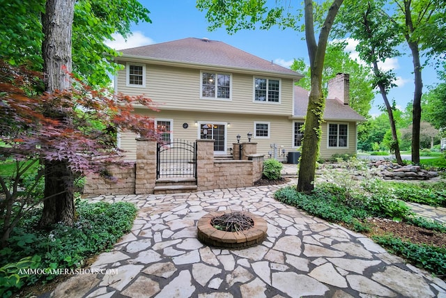 792 Black Walnut Dr, Sugar Grove, IL 60554 - rear view of property featuring a chimney, a gate, a patio area, an outdoor fire pit, and a shingled roof