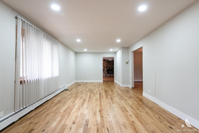 14940 Wilco Dr, Homer Glen, IL 60491 - spare room with baseboard heating, light wood-style floors, recessed lighting, baseboards, and a stone fireplace