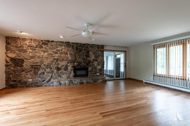 14940 Wilco Dr, Homer Glen, IL 60491 - unfurnished living room featuring wood finished floors, baseboard heating, ceiling fan, a fireplace, and baseboards