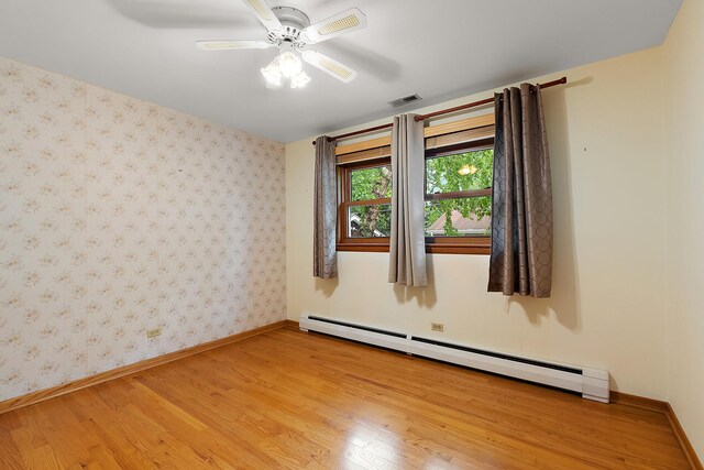 9017 S 50th Ave, Oak Lawn, IL 60453 - spare room featuring a baseboard heating unit, light wood-style floors, baseboards, and wallpapered walls