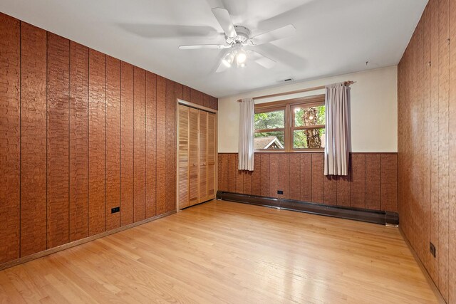 9017 S 50th Ave, Oak Lawn, IL 60453 - unfurnished bedroom with wood finished floors, a baseboard heating unit, wood walls, ceiling fan, and a wainscoted wall