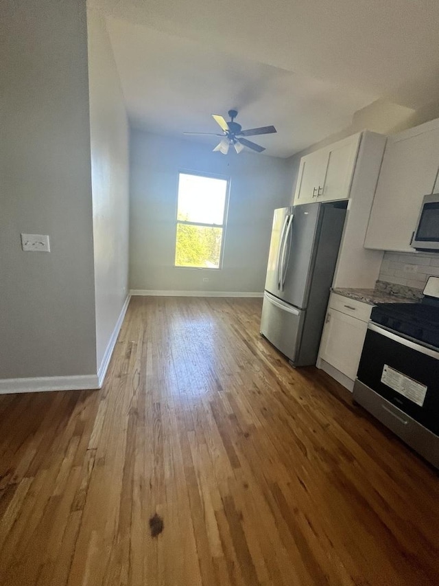 501 W 60th Pl Unit 3, Chicago, IL 60621 - kitchen featuring stainless steel appliances, wood finished floors, a ceiling fan, baseboards, and white cabinetry