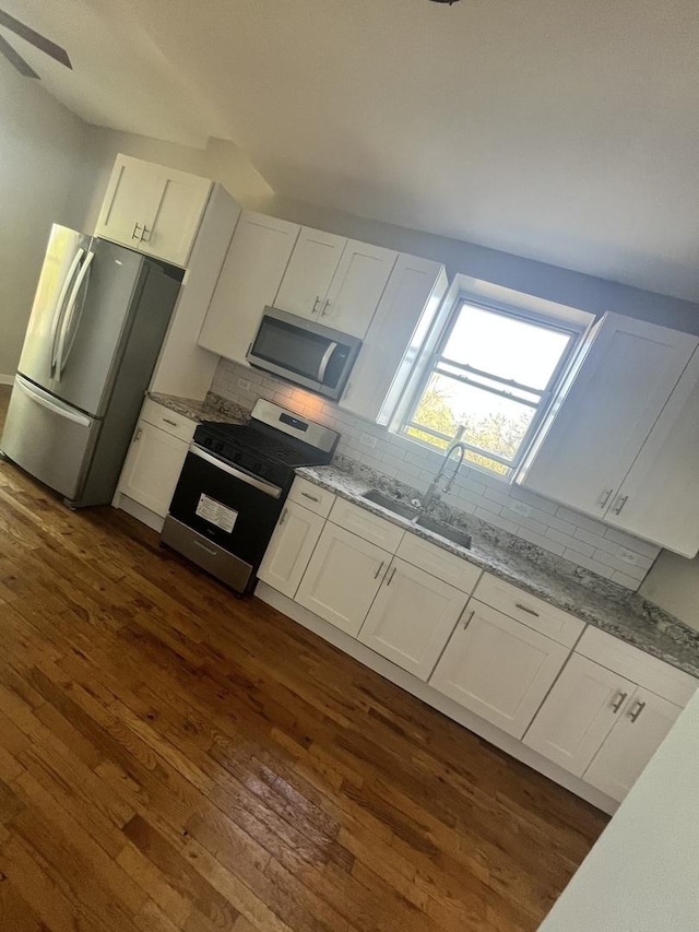 501 W 60th Pl Unit 3, Chicago, IL 60621 - kitchen with appliances with stainless steel finishes, dark wood-style floors, tasteful backsplash, and white cabinets