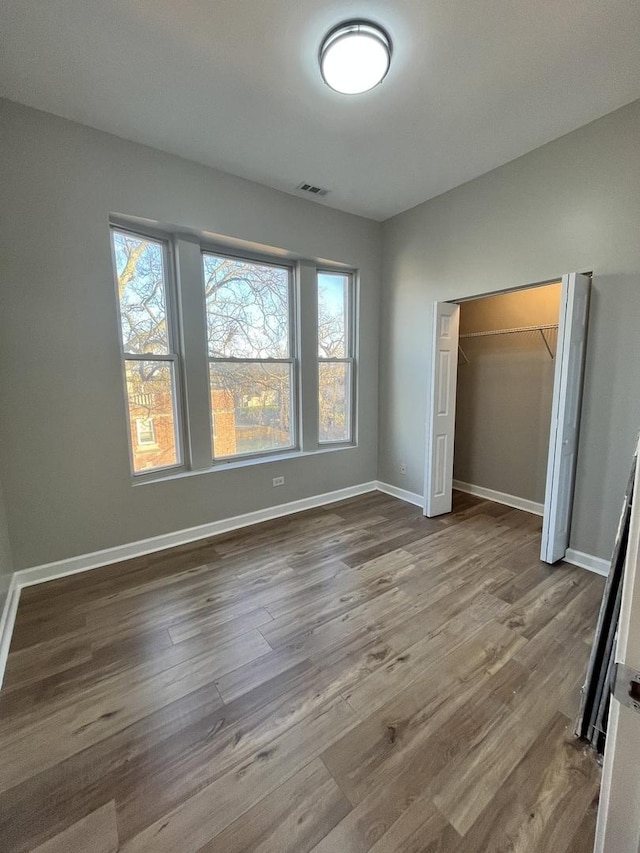 501 W 60th Pl Unit 3, Chicago, IL 60621 - unfurnished bedroom with multiple windows, wood finished floors, baseboards, and a closet