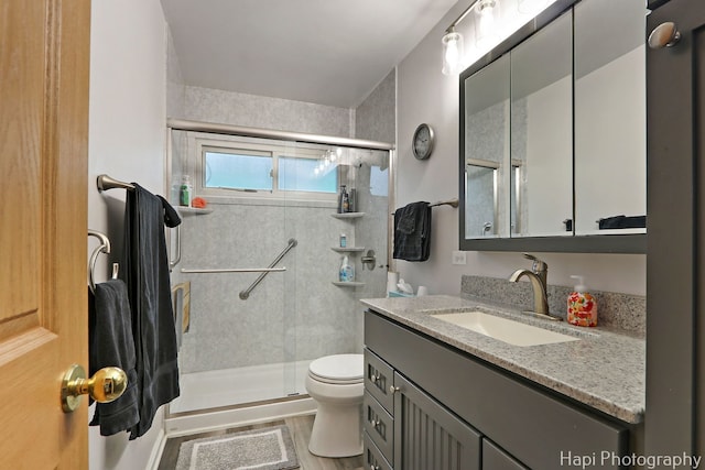 1428 Juneway Ter, Round Lake Beach, IL 60073 - bathroom featuring toilet, a shower stall, vanity, and wood finished floors