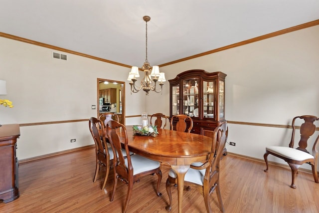 730 N Hundley St, Hoffman Estates, IL 60169 - dining space featuring a chandelier, light wood-style floors, crown molding, and baseboards