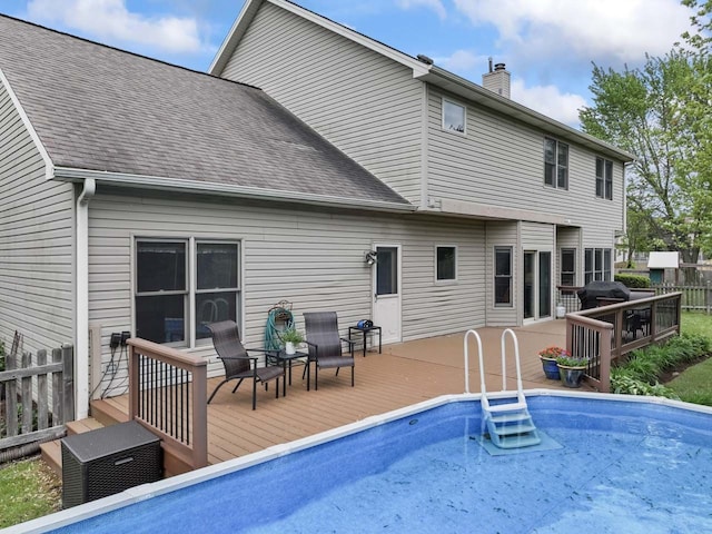 730 N Hundley St, Hoffman Estates, IL 60169 - back of house featuring a deck, a chimney, an outdoor pool, and roof with shingles