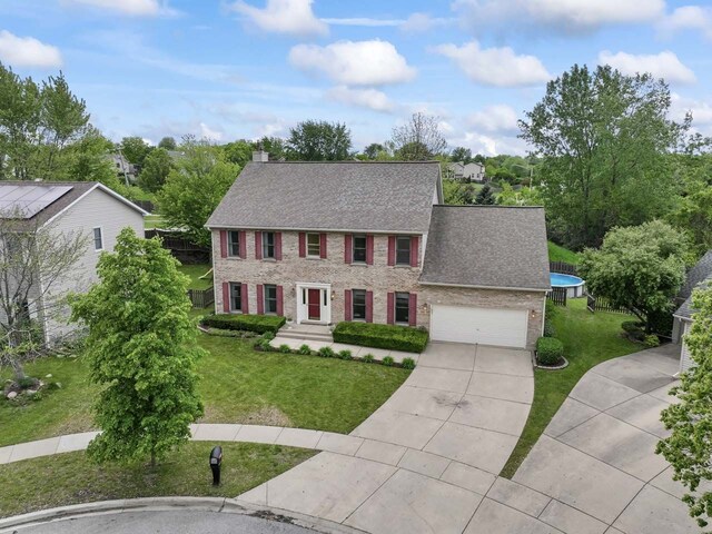 730 N Hundley St, Hoffman Estates, IL 60169 - colonial-style house featuring brick siding, concrete driveway, a front yard, and a chimney
