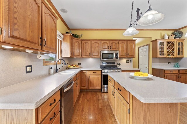 730 N Hundley St, Hoffman Estates, IL 60169 - kitchen with stainless steel appliances, a sink, light countertops, a kitchen island, and ornamental molding
