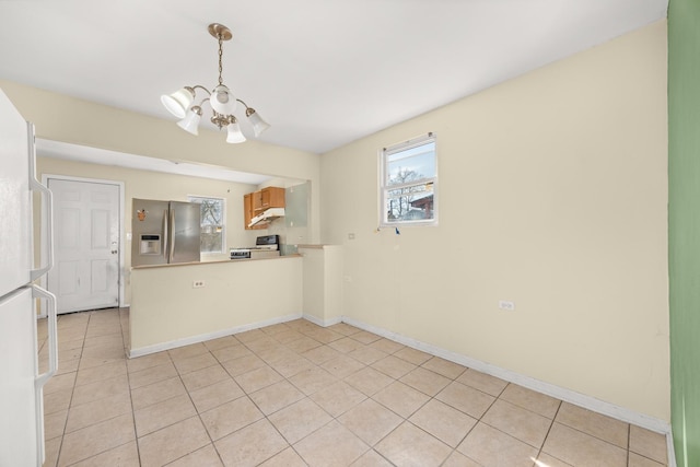 1661 Euclid Ave, Chicago Heights, IL 60411 - kitchen with stainless steel fridge, a chandelier, under cabinet range hood, a peninsula, and light tile patterned floors