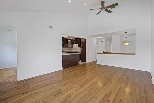 3S261 Briarwood Dr, Warrenville, IL 60555 - unfurnished living room with ceiling fan, wood finished floors, high vaulted ceiling, and baseboards