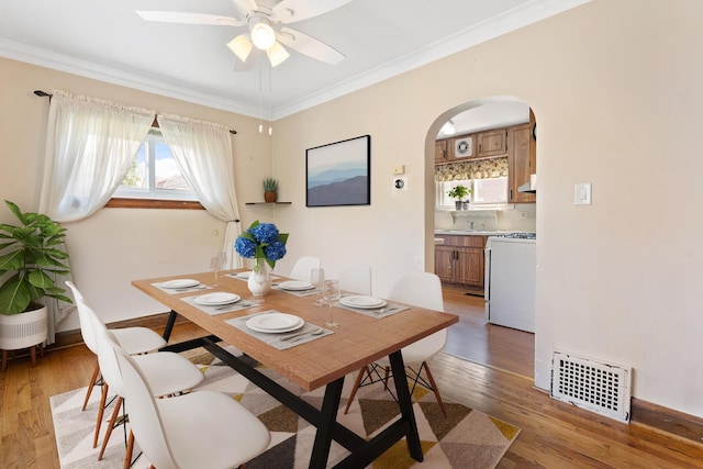 4265 Eberly Ave, Brookfield, IL 60513 - dining area with arched walkways, light wood finished floors, ceiling fan, and ornamental molding