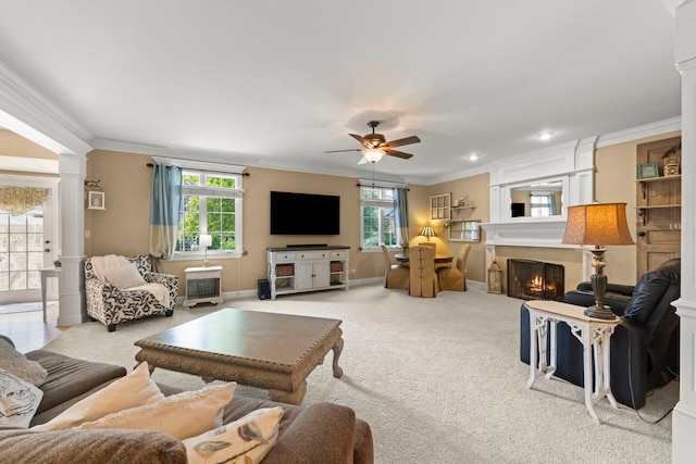 10423 Capistrano Ln, Orland Park, IL 60467 - living area featuring ornamental molding, ceiling fan, decorative columns, a warm lit fireplace, and carpet flooring