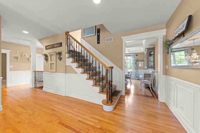10423 Capistrano Ln, Orland Park, IL 60467 - stairway with a decorative wall, plenty of natural light, wood finished floors, a wainscoted wall, and decorative columns
