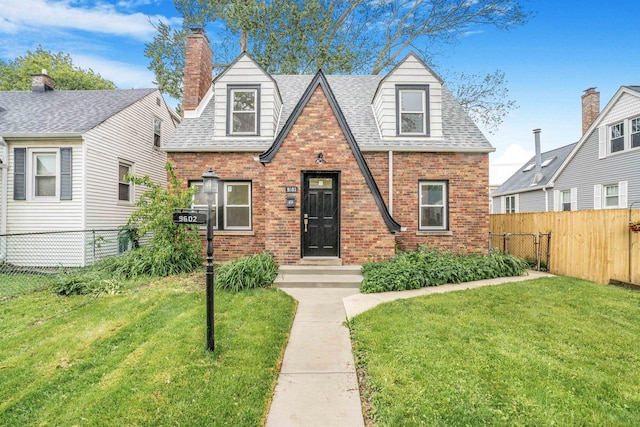 9602 S Troy Ave, Evergreen Park, IL 60805 - tudor home with brick siding, a chimney, and a shingled roof