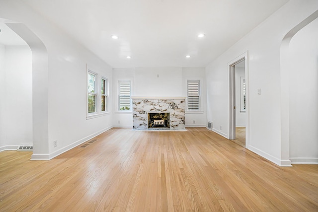 9602 S Troy Ave, Evergreen Park, IL 60805 - unfurnished living room with arched walkways, light wood-style flooring, recessed lighting, a high end fireplace, and baseboards