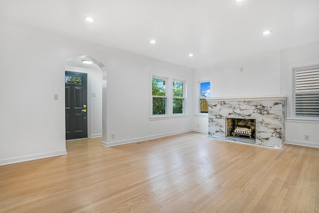 9602 S Troy Ave, Evergreen Park, IL 60805 - unfurnished living room with light wood-style floors, arched walkways, a high end fireplace, baseboards, and recessed lighting