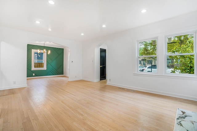 9602 S Troy Ave, Evergreen Park, IL 60805 - empty room featuring arched walkways, light wood-style flooring, a chandelier, baseboards, and recessed lighting