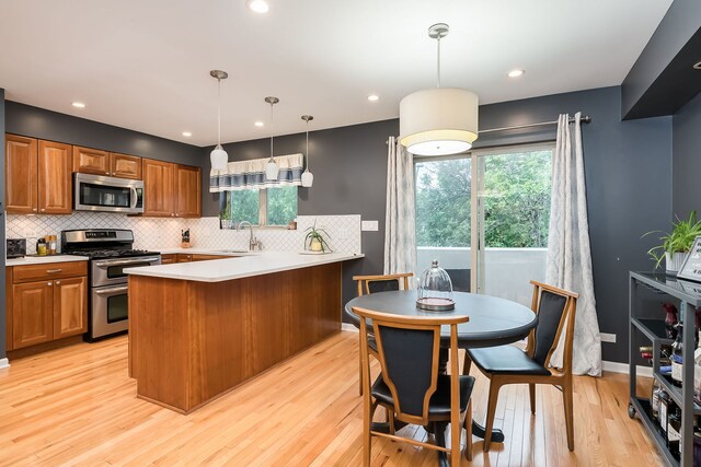 210 Des Plaines Ave Unit B, Forest Park, IL 60130 - kitchen featuring appliances with stainless steel finishes, a sink, tasteful backsplash, a peninsula, and light wood finished floors