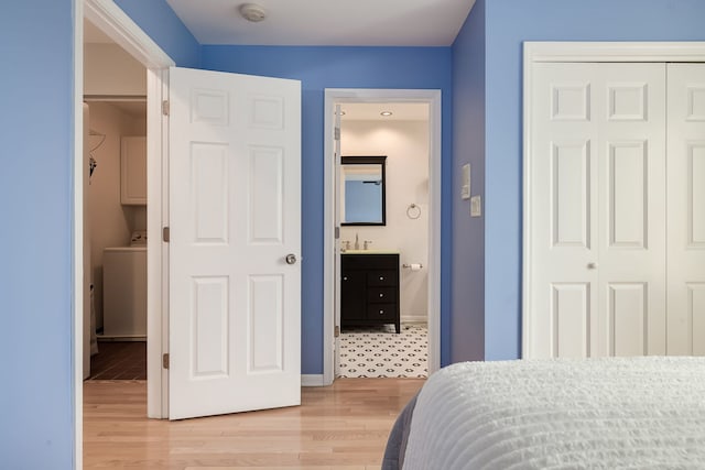 210 Des Plaines Ave Unit B, Forest Park, IL 60130 - bedroom featuring washer / dryer, a closet, a sink, light wood-type flooring, and connected bathroom