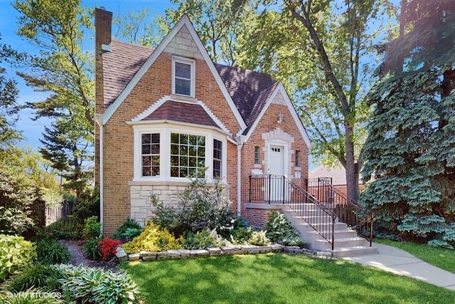 5247 Greenwood St, Skokie, IL 60077 - tudor house with a front yard, a chimney, brick siding, and stone siding