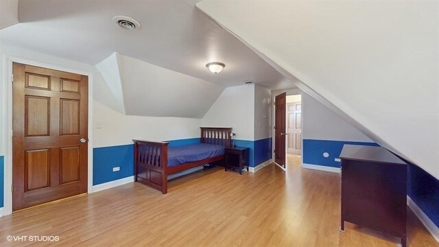 5247 Greenwood St, Skokie, IL 60077 - bedroom with wood finished floors, baseboards, and vaulted ceiling