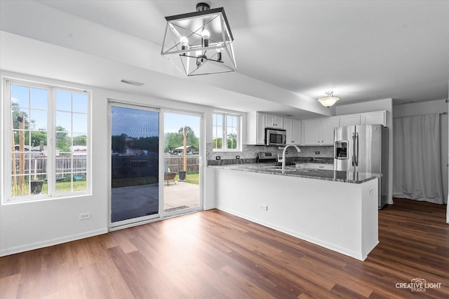 1632 Victoria Park Cir, Aurora, IL 60504 - kitchen featuring stainless steel appliances, dark wood finished floors, a peninsula, dark stone countertops, and backsplash