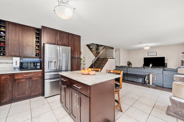 5401 W Arlington Dr, Hanover Park, IL 60133 - kitchen with stainless steel fridge, black microwave, open shelves, light tile patterned floors, and a breakfast bar area