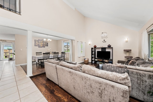 5401 W Arlington Dr, Hanover Park, IL 60133 - living area featuring a chandelier, tile patterned flooring, healthy amount of natural light, high vaulted ceiling, and baseboards
