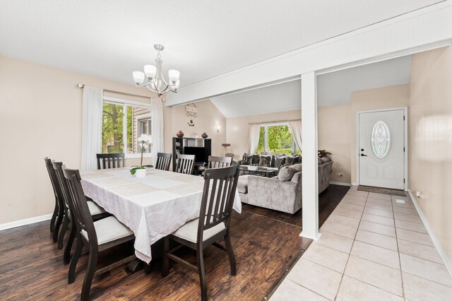 5401 W Arlington Dr, Hanover Park, IL 60133 - tiled dining area featuring a chandelier, baseboards, and lofted ceiling