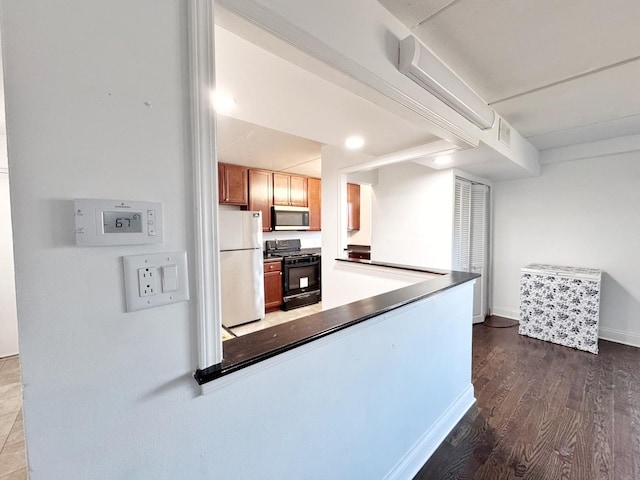 735 N Swift Rd Unit 102, Addison, IL 60101 - kitchen featuring gas stove, stainless steel microwave, freestanding refrigerator, dark wood-style floors, and baseboards