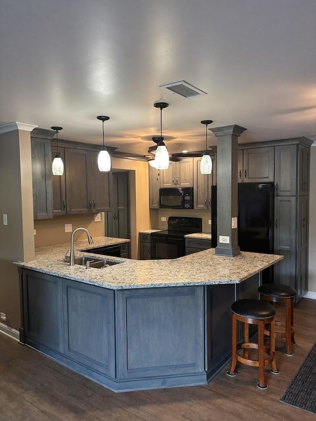 6525 Main St Unit 204, Downers Grove, IL 60516 - kitchen featuring black appliances, light stone countertops, a peninsula, and dark wood-style flooring
