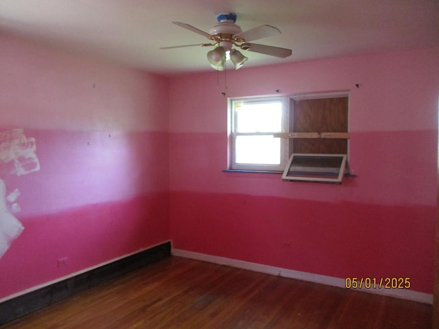 spare room with wood finished floors, a ceiling fan, and baseboards
